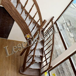 Фотография Г-образной лестницы из массива ясеня с тонировкой,  пригласительной ступенью, с ограждением с двух сторон по ходу первого марша