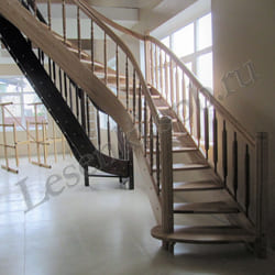 Фотография лестницы деревянной из массива ясеня, с поворотом на 90 градусов, с бесцветным лаковым покрытием. Первая ступень – пригласительная. Столбы круглые с канелюрами. Разные варианты балясин
