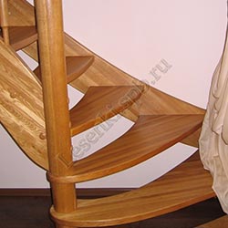 Фотография Г-образной лестницы из массива дуба с радиусными ступенями на круглом центральном столбе