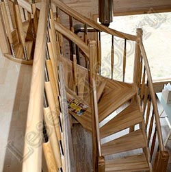Фотография Г-образной лестницы из массива ясеня с поворотом налево, с пригласительной ступенью, с ограждением с двух сторон по ходу маршей, с гнутой балюстрадой