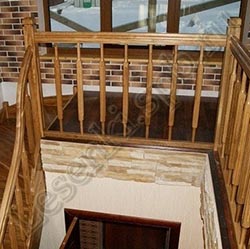 Фотография Г-образной, закрытой лестницы из массива дуба с поворотом на 90 градусов через забежные ступени на выходе, с Г-образной балюстрадой
