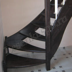 Фотография лестницы с поворотом на 90 градусов через забежные ступени, из массива ясеня с тонировкой, с белыми балясинами